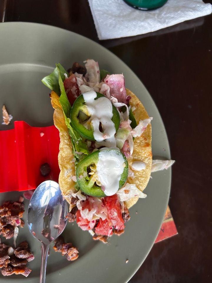Founder-owned photograph of a corn tortilla taco with lettuce, tomato, cabbage, jalapeños and dressing on a plate