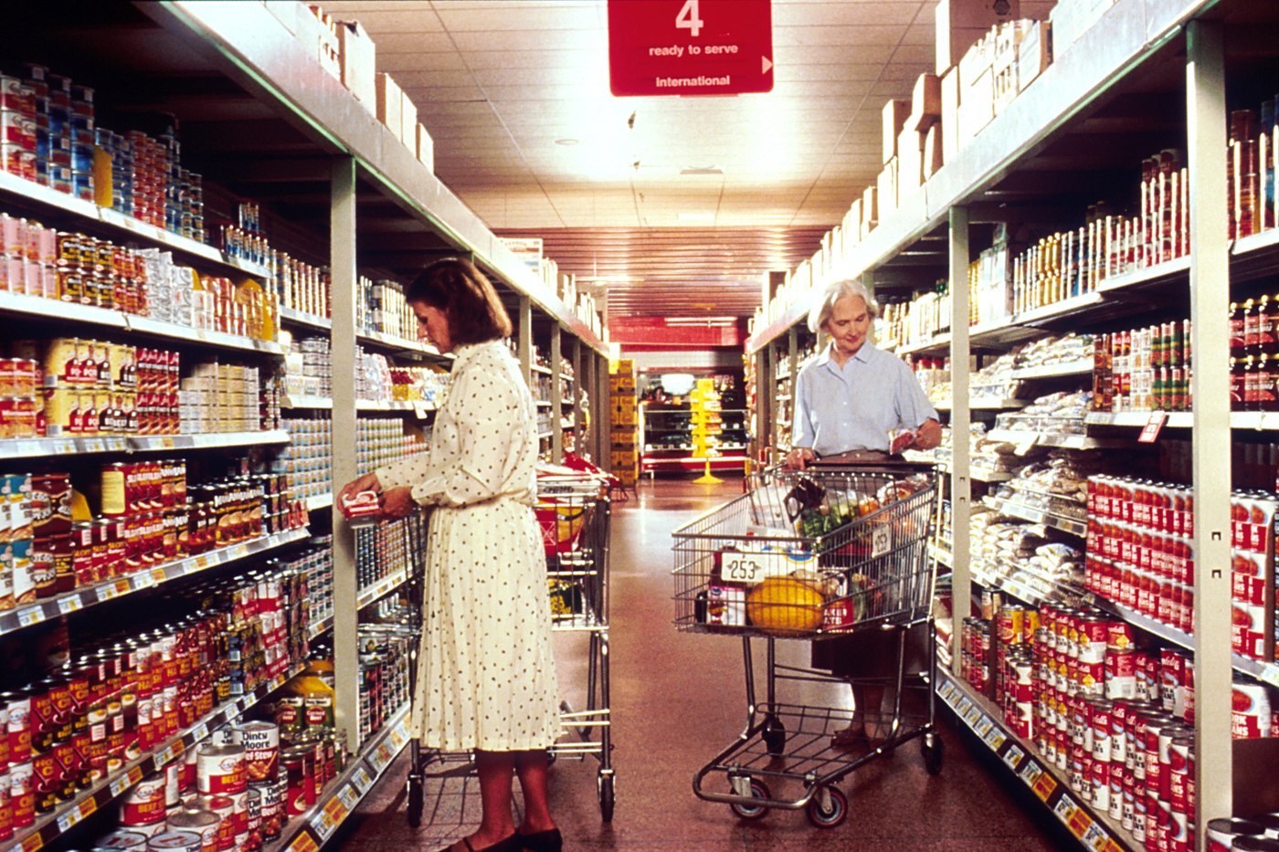 Two women choosing groceries in an aisle in an archival 1989 photograph